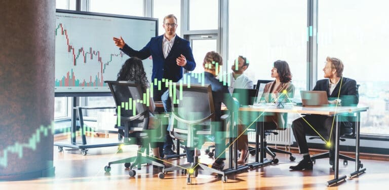 Businessman Leading Meeting in Modern Office With Financial Chart Displayed